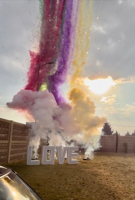 Humo de colores enmarcando un letrero de LOVE para sesión de fotos de boda