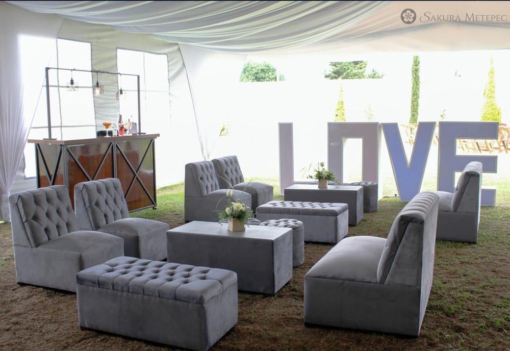 Área lounge exterior con letras decorativas LOV y sillones acojinados