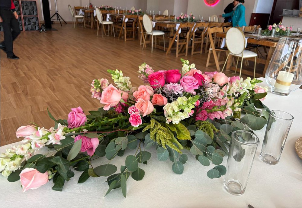 Ramo floral rosa y blanco como centro de mesa en recepción de boda