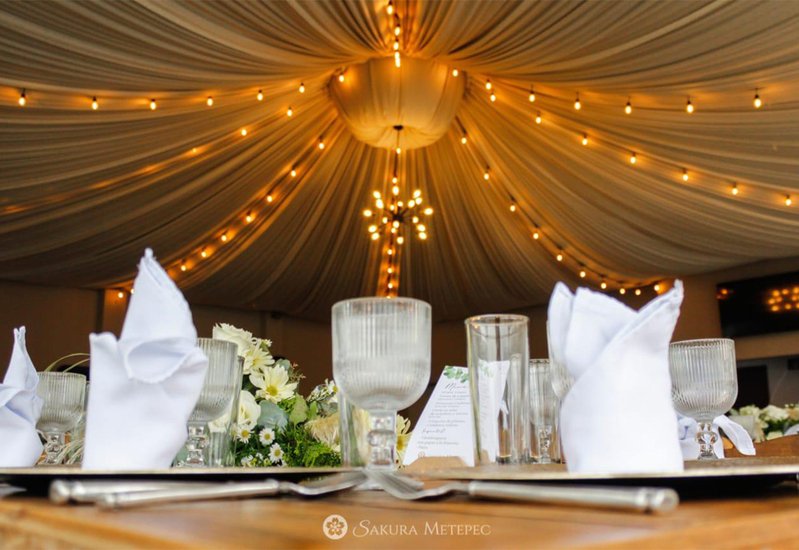 Detalle de luces cálidas en forma de estrella en el techo de la carpa de boda