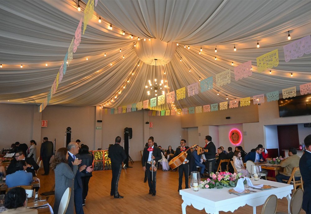 Carpa decorada con luces y papel picado para una recepción de boda festiva