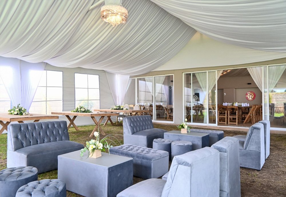 Carpa de recepción con cortinaje blanco y sala lounge gris para boda en Sakura Metepec