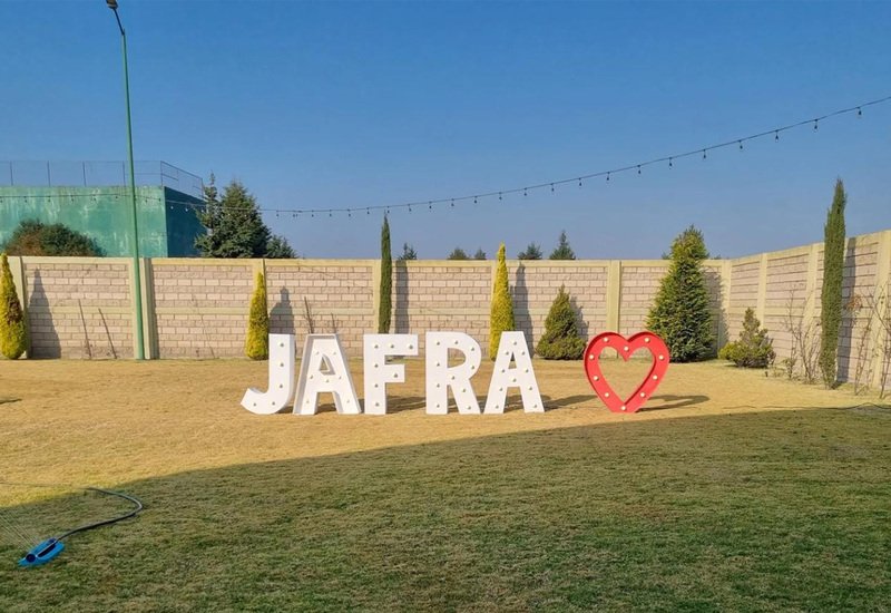 Letras gigantes JAFRA con corazón en el jardín de Sakura durante evento de empresa