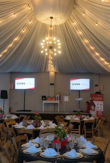 Pantallas con logotipo UVM y escenario montado en el salón de Sakura para evento institucional