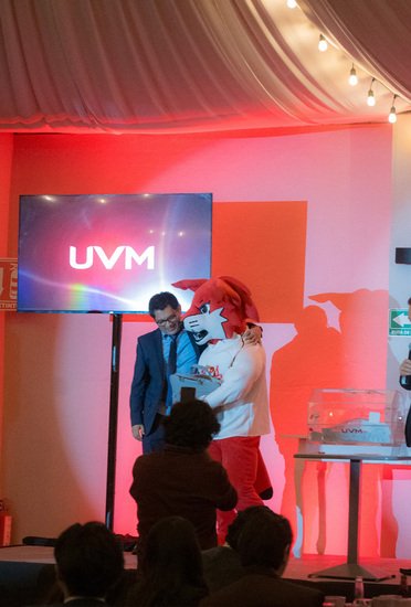 Presentación en escenario con mascota UVM durante evento institucional en Sakura Metepec