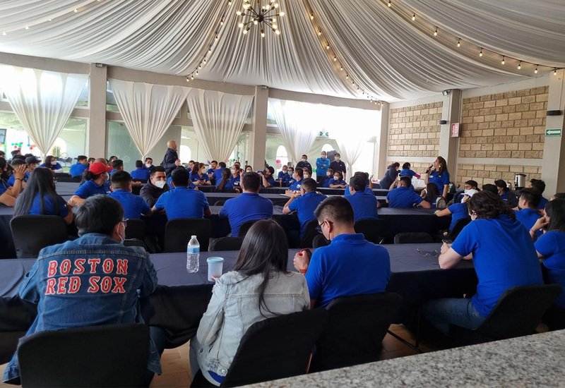 Asistentes de evento corporativo sentados en mesas imperiales dentro del salón Sakura