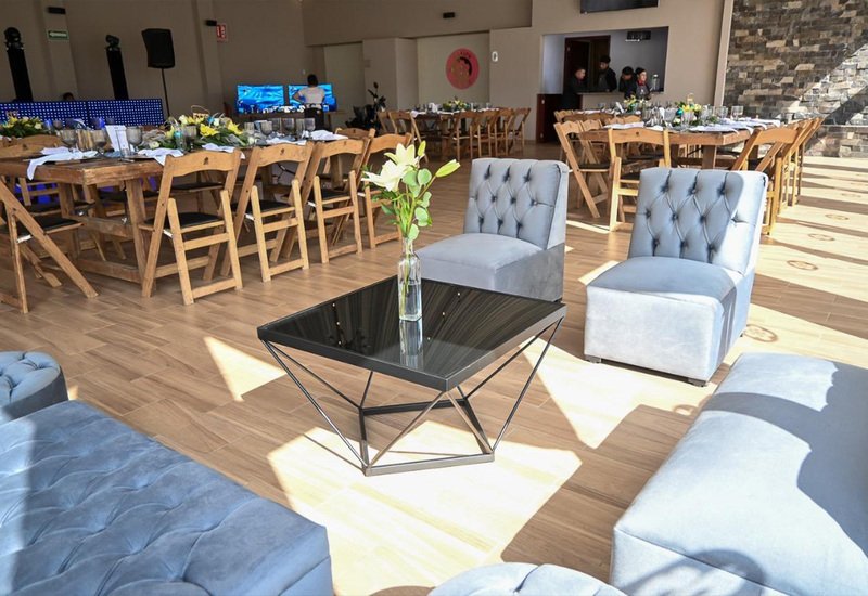 Sala lounge con sillones capitonados y mesa de centro en evento corporativo de Sakura Metepec