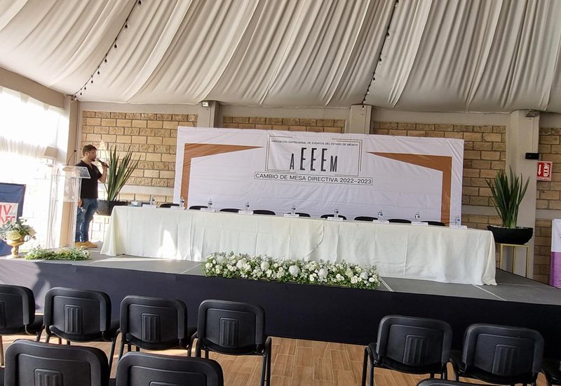 Presídium con mesa de honor y escenario para conferencia corporativa en Sakura Metepec