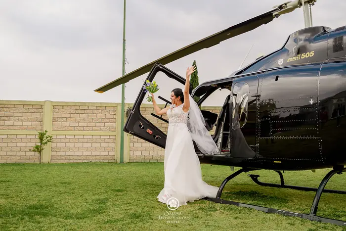 Novia emocionada bajando del helicóptero al llegar a su boda en Sakura Metepec