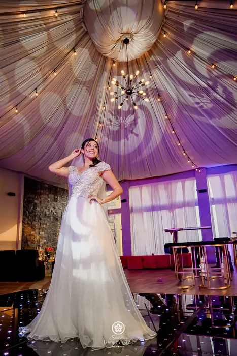 Novia en el salón Sakura con techo entelado, candil vintage y pista iluminada