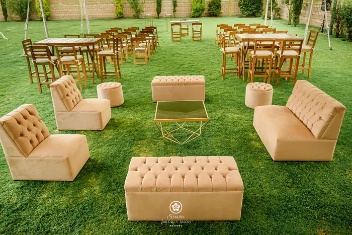 Sala lounge de terciopelo y periqueras de madera en el jardín para recepción de boda