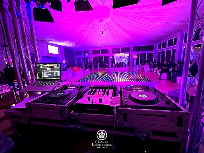 Cabina de DJ profesional frente a la pista LED iluminada del salón Sakura Metepec