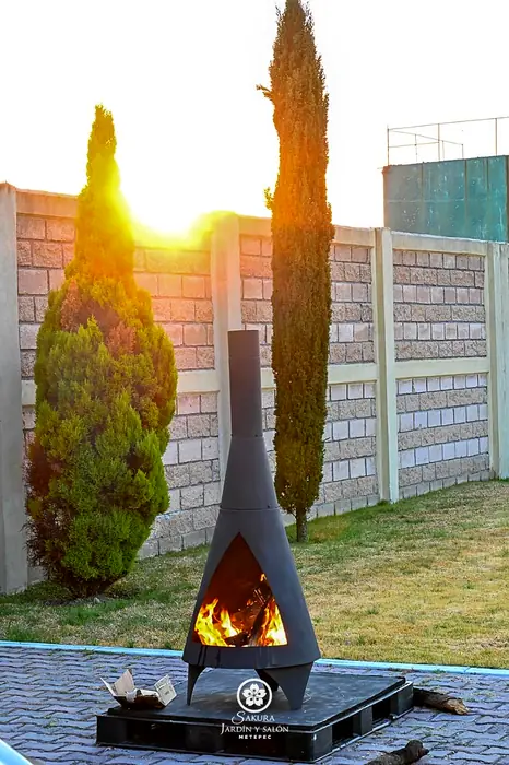 Chimenea de leña en el jardín de Sakura Metepec al atardecer
