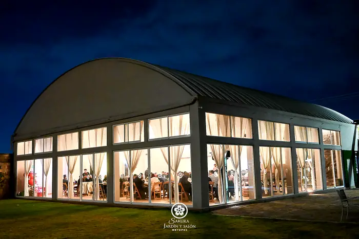 Salón de cristal de Sakura Metepec iluminado de noche durante un evento