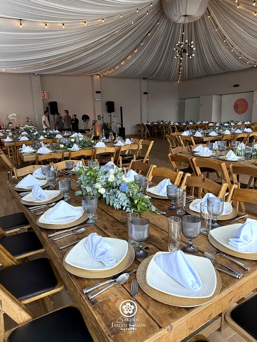 Salón Sakura montado con mesas de madera, loza, cristalería y centros florales