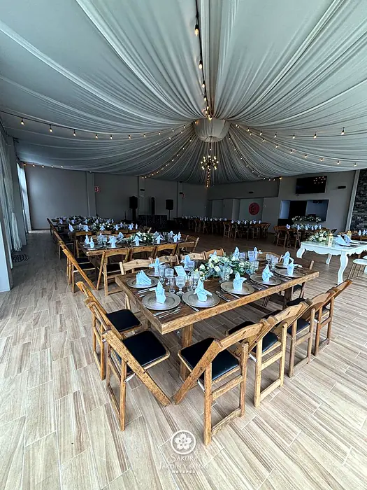 Salón Sakura montado con mesas de madera, centros florales y mesa de honor